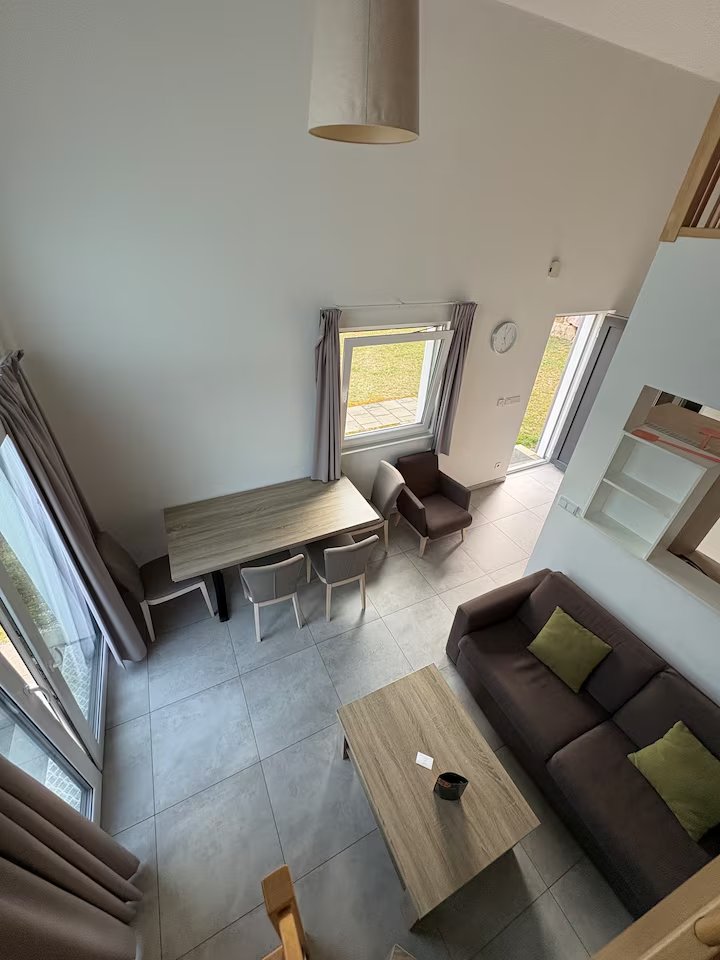 Essbereich mit hohem Deckenschrägen-Raum, Esstisch und Sofalandschaft – Ferienhaus Obernsees